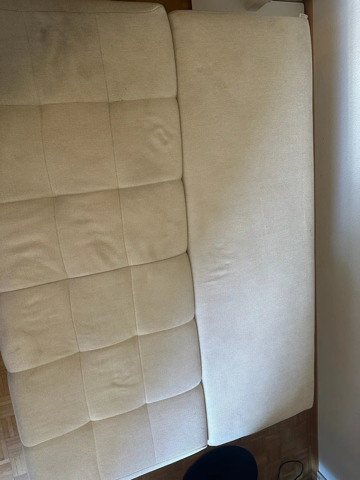 Helles Stoffsofa mit vergrautem Bezug, daneben eine bereits gereinigte Fläche