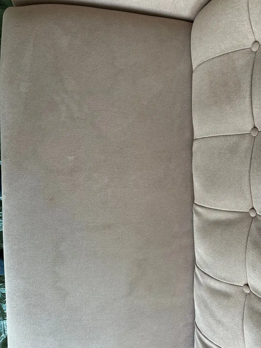 Beige Sofa-Sitzfläche mit grauem Schleier vor der Polsterreinigung