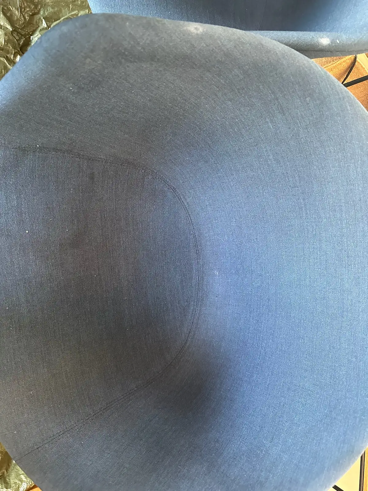 Dunkelblaue Sitzfläche eines Polsterstuhls mit mattem Grauschleier vor der Reinigung